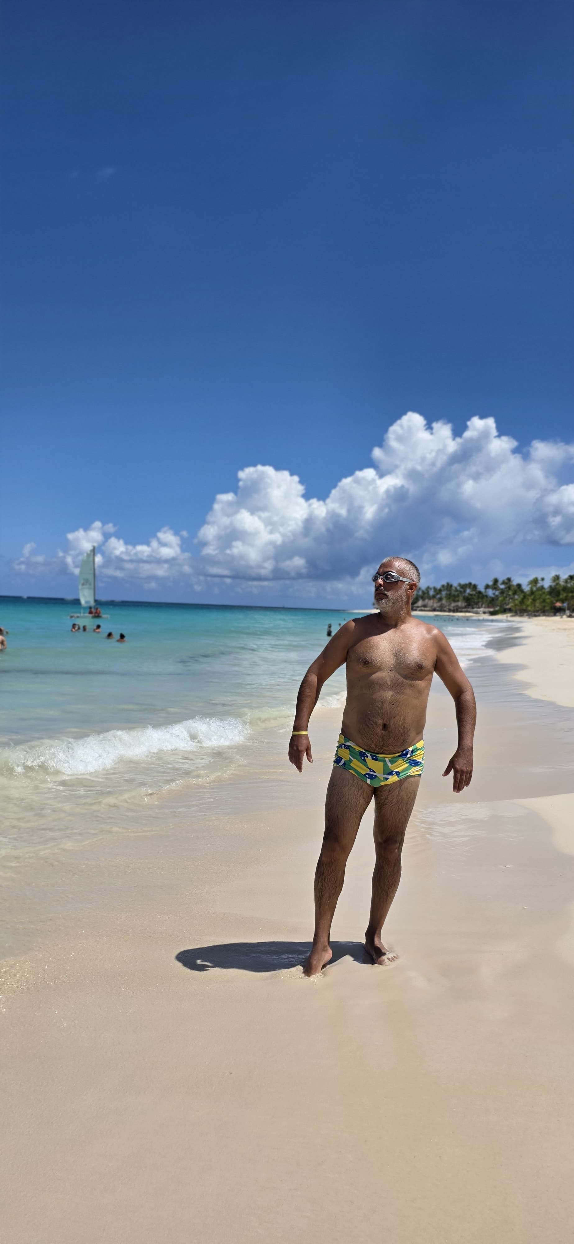 Persona posando en la orilla del mar con gafas de natación